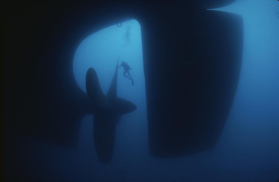 Scuba diver cleaning a 30-foot propeller of a 226,000 ton tanker