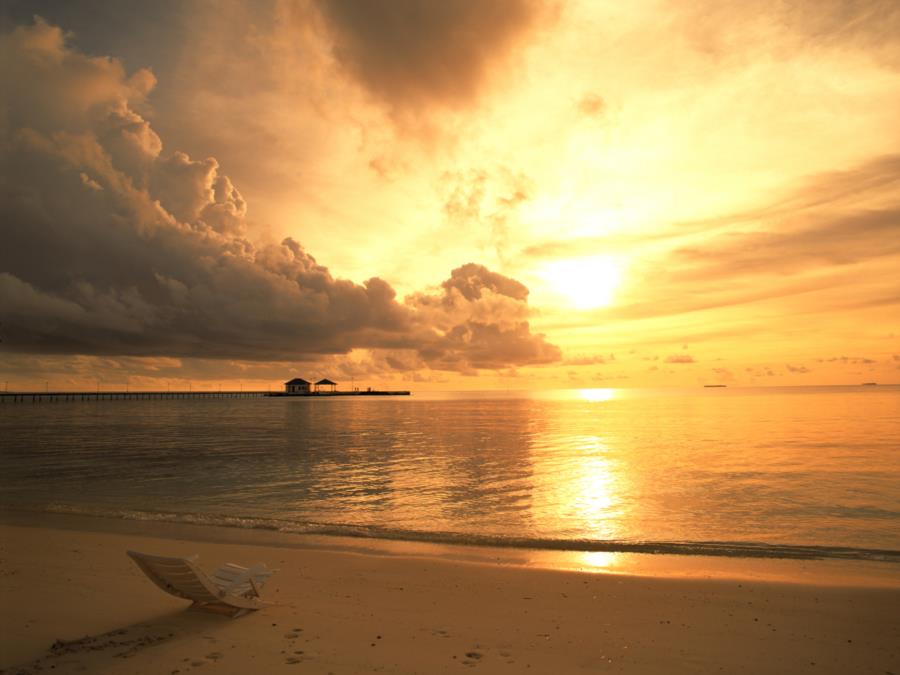 Sunset over water, pier in distance