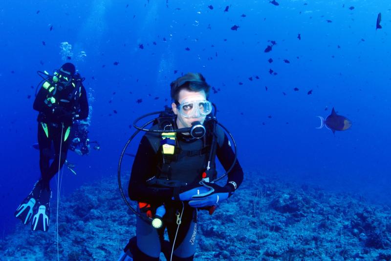 Me in the backround on a reef hook, Blue Corner Palau